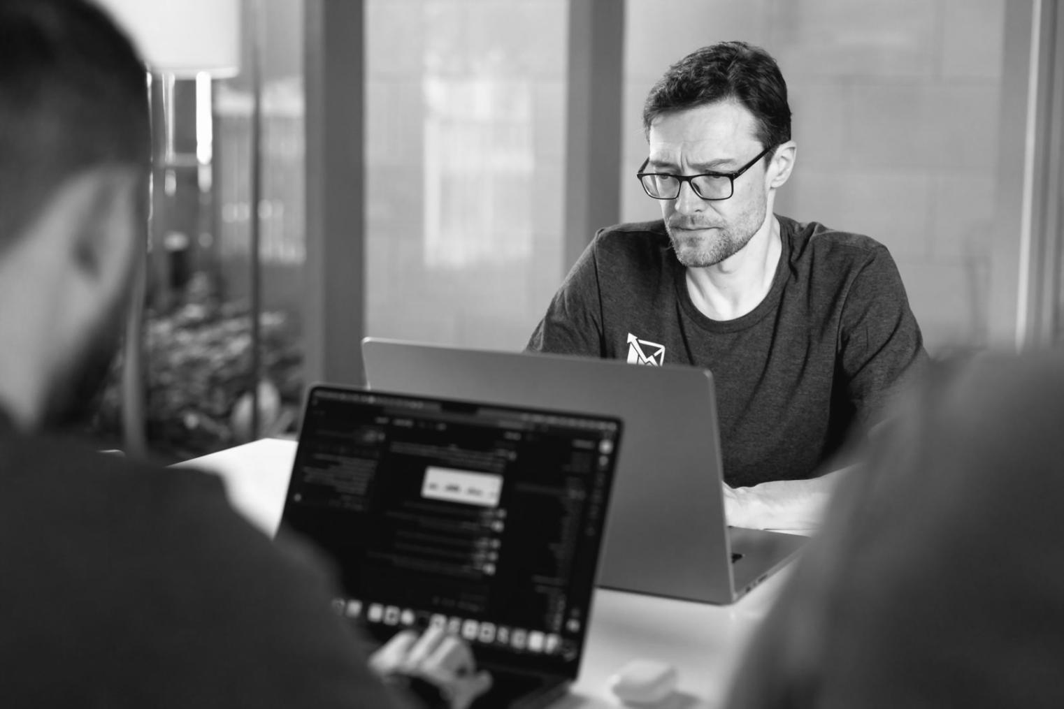 Person arbeitet konzentriert mit Finanzberichten und Laptop
